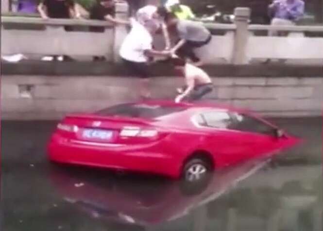 Pedestres saltam em rio para salvar mulher que afundava dentro de seu carro