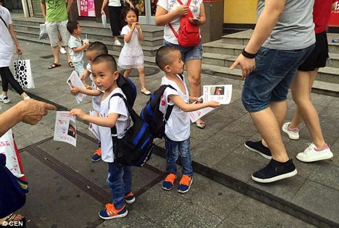 Trigêmeos de cinco anos são vistos distribuindo folhetos na rua à procura da mãe