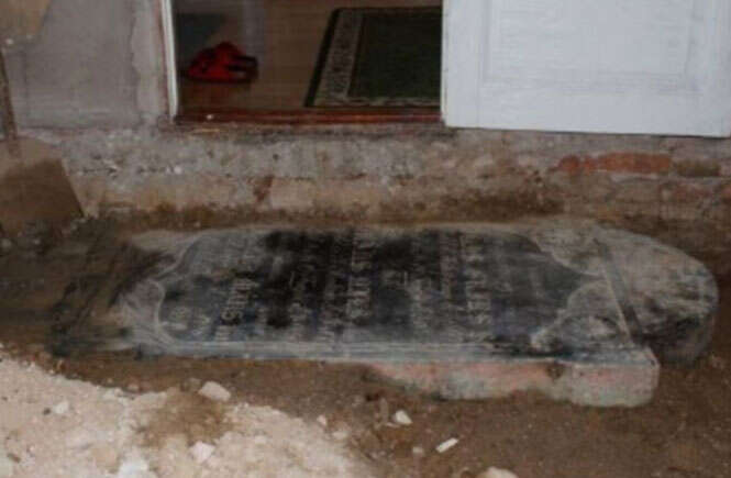 Família encontra lápide com nomes dos três antigos moradores da residência embaixo do sofá