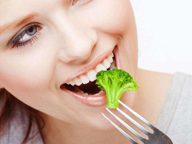 Mulher comendo brócolis