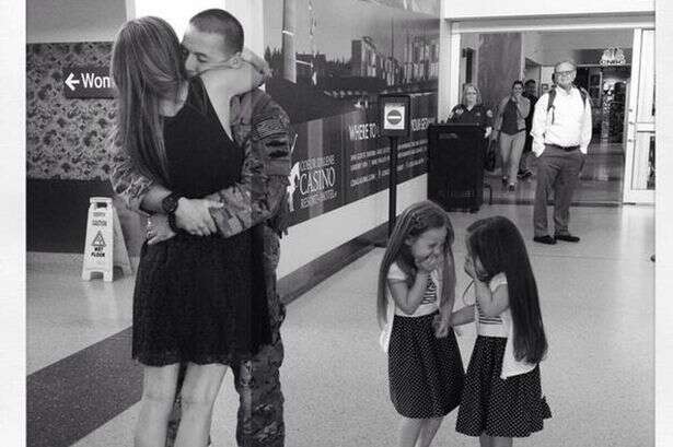 soldado abraçando esposa e filhas