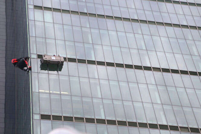 Homem com paraquedas preso em edifício