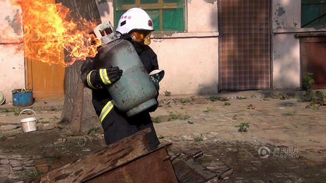 Bombeiro arrisca a vida ao correr com cilindro de gás em chamas