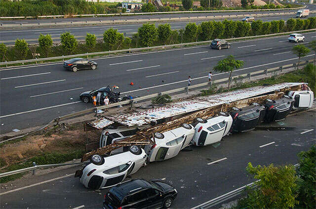 Caminhão transportando 11 carros de luxo tomba em rodovia na China
