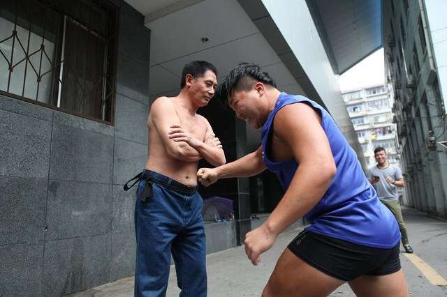 Homem anda pela China pedindo para baterem em seu estômago