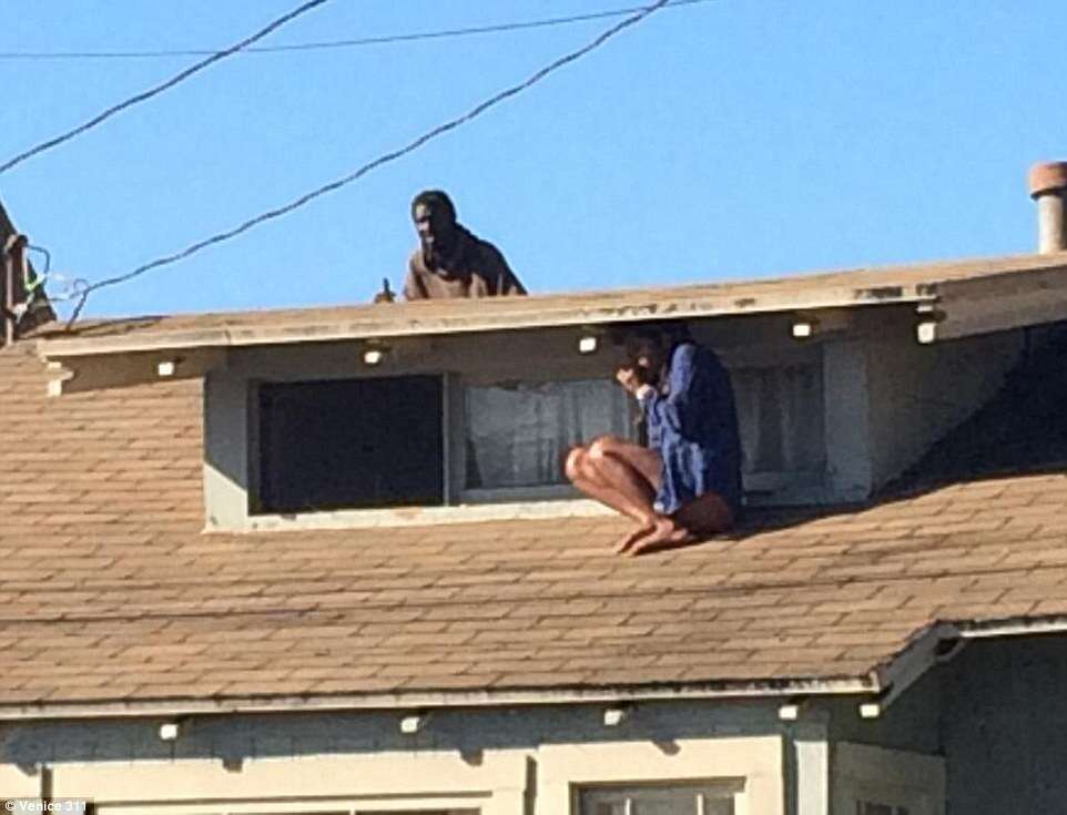 Imagem chocante mostra mulher se escondendo no telhado para fugir de criminoso
