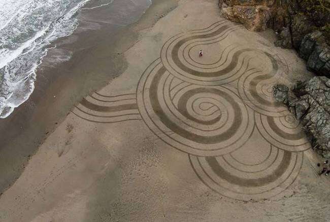 Artista faz sucesso criando arte em areia de praia