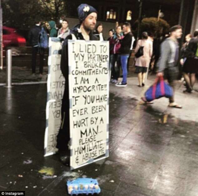 Homem permite que pessoas atirem ovos nele enquanto se veste com cartaz onde assume que traiu sua companheira