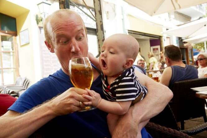 Baby trying to drink beer