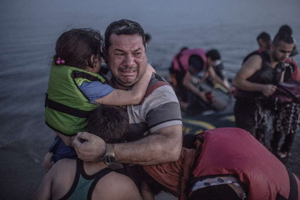 Foto surpreendente de pai abraçando seus filhos ao escapar da guerra na Síria comove o mundo
