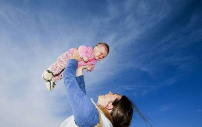 Mother Holding Her Baby Up in the Sky