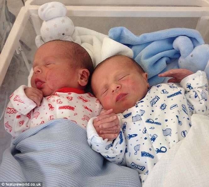 Recém-nascido é visto entrelaçando as mãos com irmão gêmeo