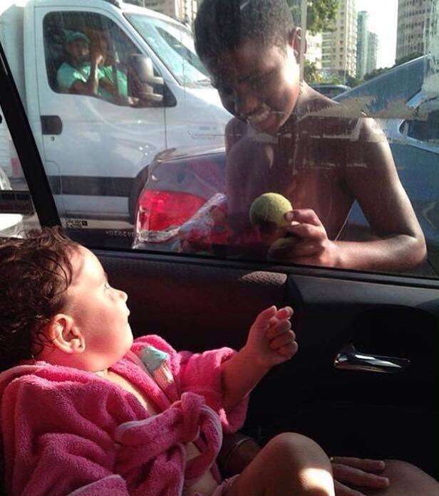 Menino de rua ganha nova esperança após ser fotografado brincando com bebê através da janela de táxi 