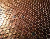 Mulher cobre todo o piso da sala de casa com moedas de 1 centavo