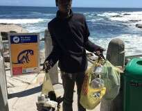 Morador de rua limpar praia por sentir vergonha da poluição no local