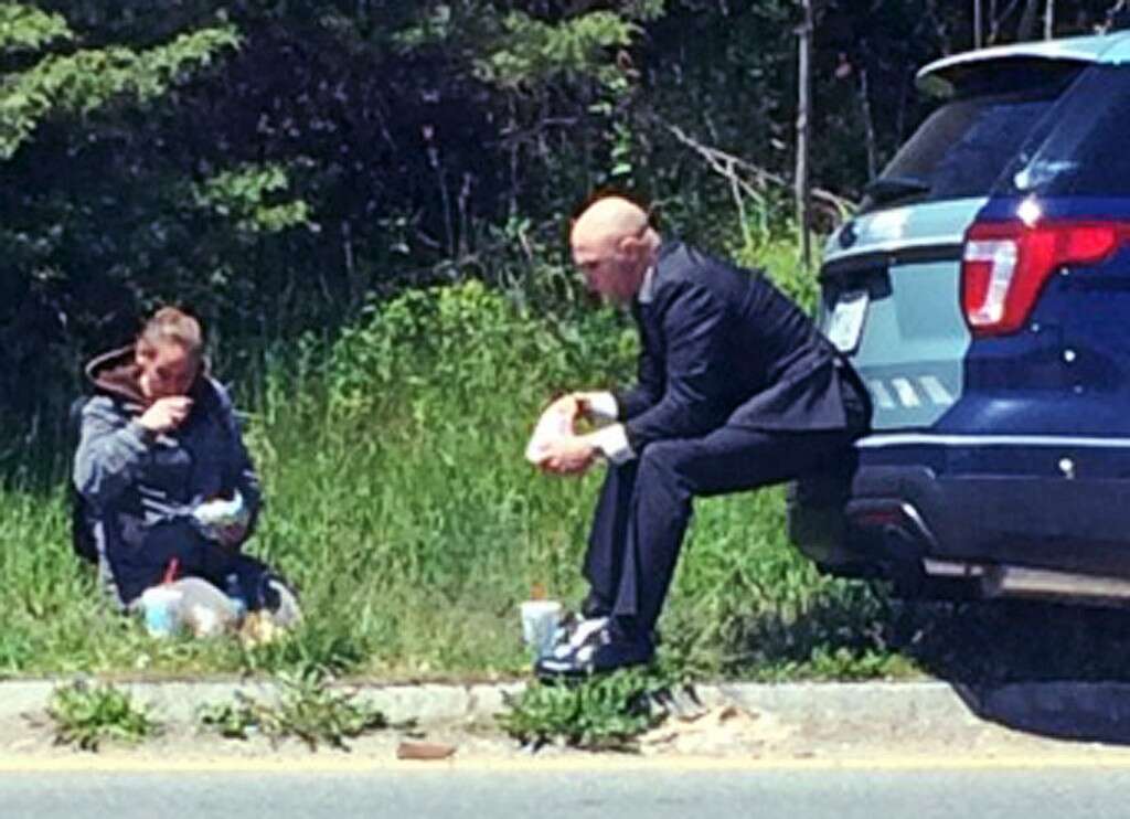 Policial norte-americano é flagrado comendo ao lado de moradora de rua