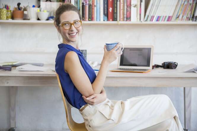 Young woman sitting with mug in home office