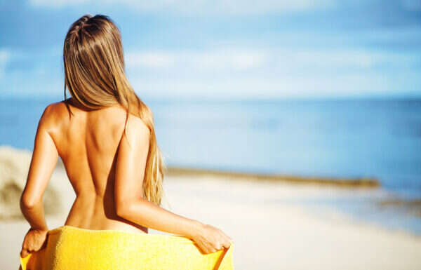 Mulher em praia de nudismo